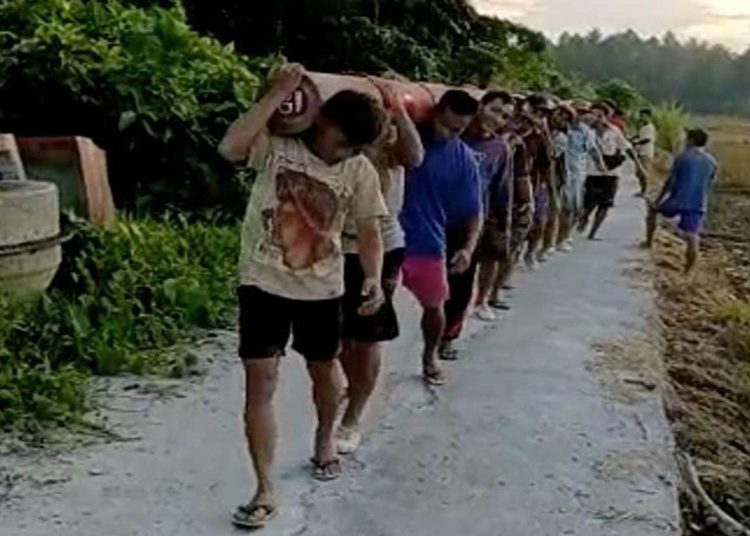 Masyarakat secara gotong royong membantu petugas PLN memikul tiang listrik dalam proses pembangunan jaringan listrik di Desa Hiliwaele II, Kecamatan Botomozoi, Kepulauan Nias, Sumatera Utara.(Foto/HO-Humas PLN UID Sumut)