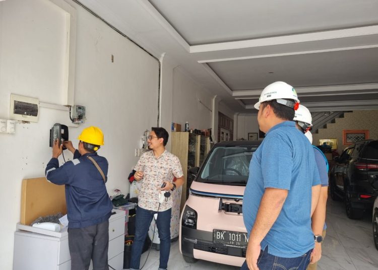 Simulasi petugas PLN UID Sumut melakukan pengecasan mobil listrik  menggunakan home charging di salah satu rumah pemilik kendaraan listrik di Kota Medan.(Satunusantara News/HO-Humas PLN UID Sumut).