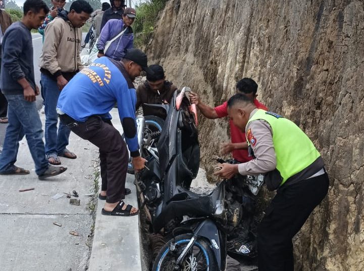 Personel Polsek Siborongborong, saat mengangkat sepeda motor milik korban Pangulu Siahaan (48) yang mengalami kecelakaan di  Jalan Umum KM 08-09 Siborongborong-Sipahutar, Desa Lobusiregar, Kabupaten Taput. (Satunusantara news/HO-Humas Polres Taput).