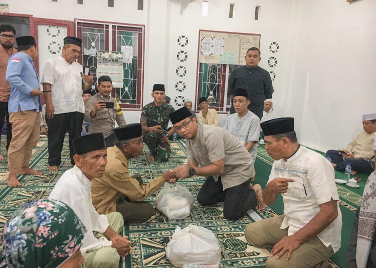 Plt Sekretaris Daerah  Kota Padangsidimpuan, Roni Gunawan Rambe (tengah) saat menyerahkan bantuan sembako kepada warga  di Masjid Al-Karim Saba Jae, Kelurahan Panyanggar.(Satunusantara news/HO-Kominfo Padangsidimpuan).