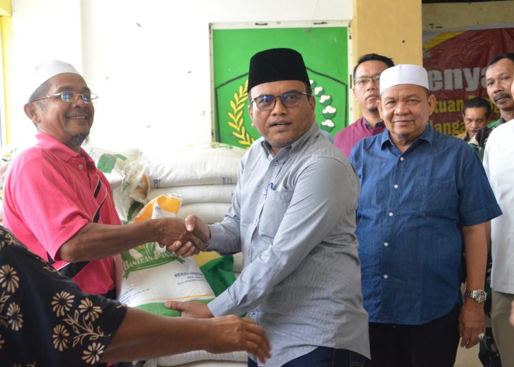 Pj Wali kota Padangsidimpuan, Dr. H. Letnan Dalimunthe, SKM, M. Kes (kanan) saat menyerahkan  bantuan pangan cadangan beras Tahap II Tahun 2024  kepada masyarakat. (Satunusantara news/HO-Kominfo Padangsidimpuan).