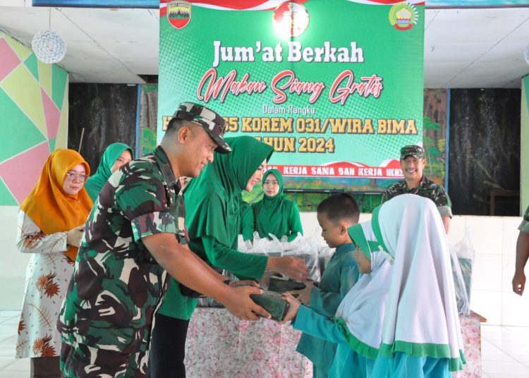 Kasrem 031/Wira Bima Kolonel Kav Eko Agus Nugroho (kiri) membagikan makan siang gratis kepada siswa dan siswi sekolah dasar, dalam rangka memperingati HUT,ke-65 Korem 031/WB.(Satunusantara news/HO-Penrem 031/WB).