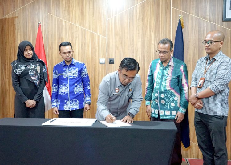 Kakanwil Kemenkumham Sumut Anak Agung Gde Krisna (tengah) saat menandatangani  Penetapan Standar Operasional Pelayanan Kanwil Kemenkumham Sumut.(Satunusantara news/HO-Humas Kemenkumham Sumut).