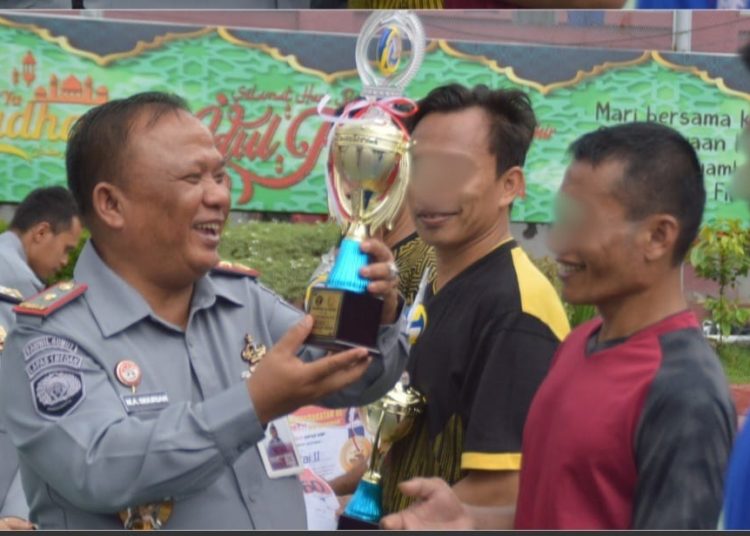 Kalapas I Medan Maju Amintas Siburian (kiri) saat menyerahkan hadiah berupa piala kepada WBP sebagai pemenang lomba kegiatan olahraga pemasyarakatan.(Satunusantaraa news/HO-Humas lapas Medan).