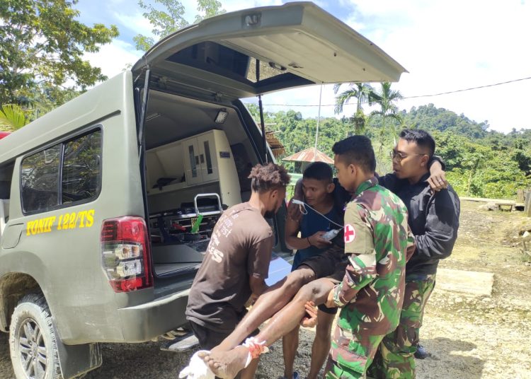 Personel Satgas Pamtas RI- PNG Yonif 122/TS memberikan pertolongan kepada warga yang mengalami luka di bagian kaki, di Kampung Sawiyatami, Distrik Mannem, Kabupaten Keerom, Papua.(Satunusantara news/HO-Yonif 122/TS).