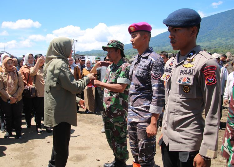 Ibu Panglima TNI, Evi Shopia Indra Subiyanto (kiri) saat menyerahkan bantuan di Bukik Batabuah, Kabupaten Agam, Sumatera Barat.(Satunusantara news/Pendam I/BB).