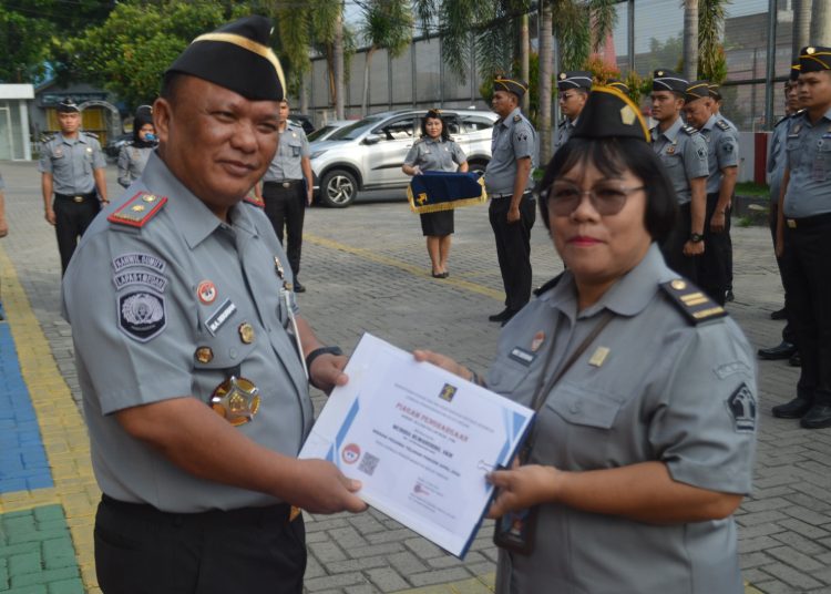 Kalapas Kelas I Medan Maju Amintas Siburian (kiri) saat  menyeraahkan penghargaan kepada seorang petugas teladan di Lapas Medan  Meirida Rumahorbo.(Satunusantara news/HO-Humas Lapas Medan).