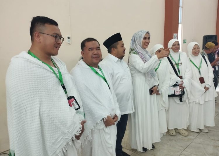 Bupati Tapsel Dolly Pasaribu (tengah) didampingi Ketua TP PKK Ny Rosalina Dolly Pasaribu foto bersama dengan  JCH Tapsel di Asrama Haji Medan.(Satunusantara news/Munawar).