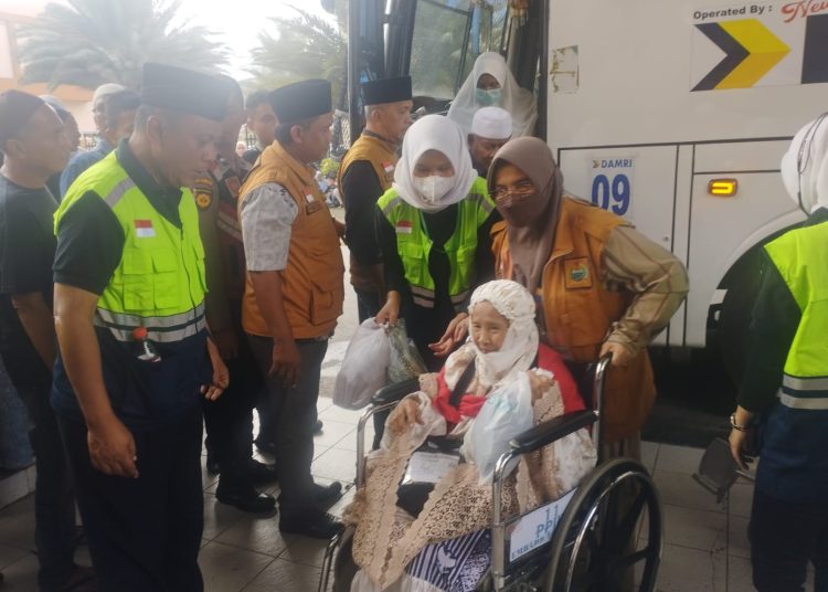Seorang jemaah haji lansia dari Kloter 02 Debarkasi Medan, saat turun dari bus dan memasuki Aula 1 Madinatul Hujjaj Asrama Haji Medan.(Satunusantara news/Munawar).