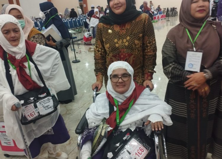 Wakil Bupati Madina, Ibu Atika Azmi Utammi Nasution, saat mendorong kursi roda  milik Hajah Mei Binti Tohir (57) jemaah haji tunanetra asal Kabupaten Madina.(Satunusantara news/Munawar).
