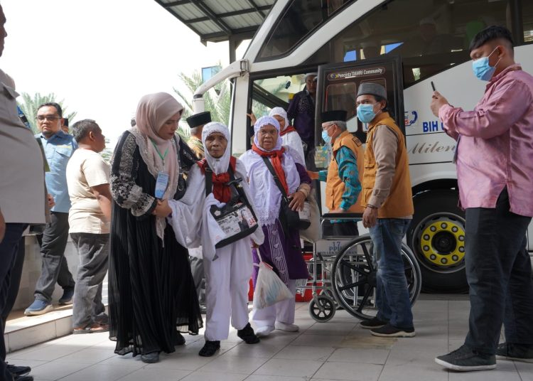 PPIH Debarkasi Medan sedang membantu seorang jemah haji lansia dari Kloter 15 Debarkasi Medan yang  turun dari Bus menuju  Aula 1 Madinatul Hujjaj Asrama Haji Medan.(Satunusantara news/HO-Humas Haji Medan).,