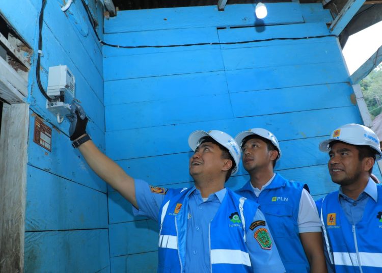 Bupati Kabupaten Labuhan Batu Utara, Hendriyanto Sitorus bersama Manajer PLN UP3 Rantauprapat, Sendy Rudianto (tengah) melakukan penyalaan salah seorang masyarakat  di Kabupaten Labuhan Batu Utara.(Satunusantara news/HO-Humas PLN UID Sumut).