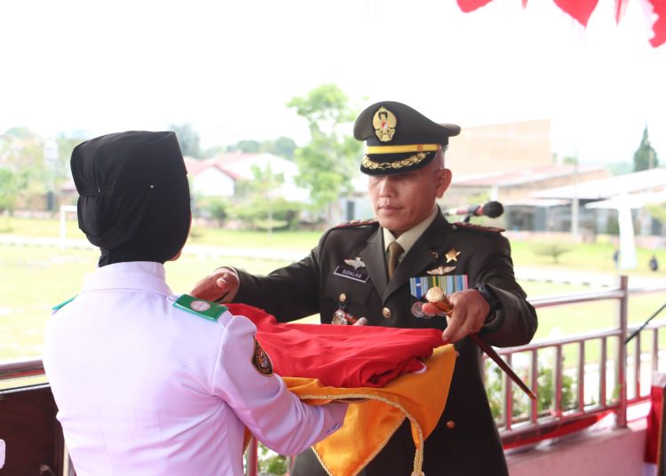 Dandim 0206/Dairi, Letkol Inf Goklas Pirtahan Silaban (kanan) saat menerima bendera merah putih dari petugas pengibar  bendera pada acara penurunan bendera peringatan HUT Kemerdekaan RI ke-79.(Satunusantara news/HO-Kodim 0206/Dairi).
