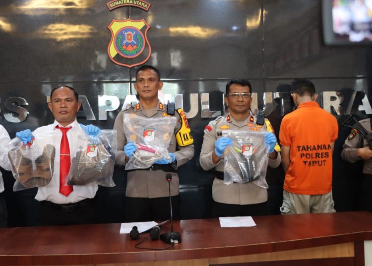 Kapolres Taput AKBP Ernis Sitinjak (tengah) saat memperlihatakan  barang bukti milik pelaku pembunuhan BSH ( 38)  terhadap korban pegawai Akper di Tarutung,, MH (45).(Satunusantara news/HO-Humas Polres Taput).