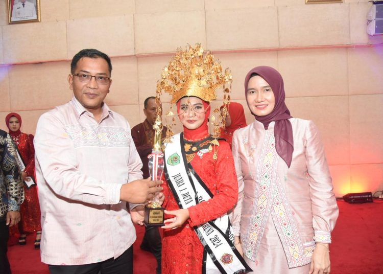 Plt Bupati Tapsel, Rasyid Assaf Dongoran (kiri) saat menyerahkan tropi kepada duta Boru Namora Tapsel 2024, Salsabila Fitri Hasibuan dengan skor 265 mewakili Kecamatan Angkola Muara Tais.(Satunusantara news/HO-Prokopim Tapsel).