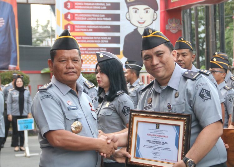 Kepala Divisi Administrasi, Kanwil Kemenkumham Sumut, Sahata Marlen Situngkir (kiri) saat memberikan penghargaan kepada pegawai yang berprestasi di halaman kantor Kemenkumham Sumut.(Satunusantara news/HO-Humas Kemenkumham Sumut).