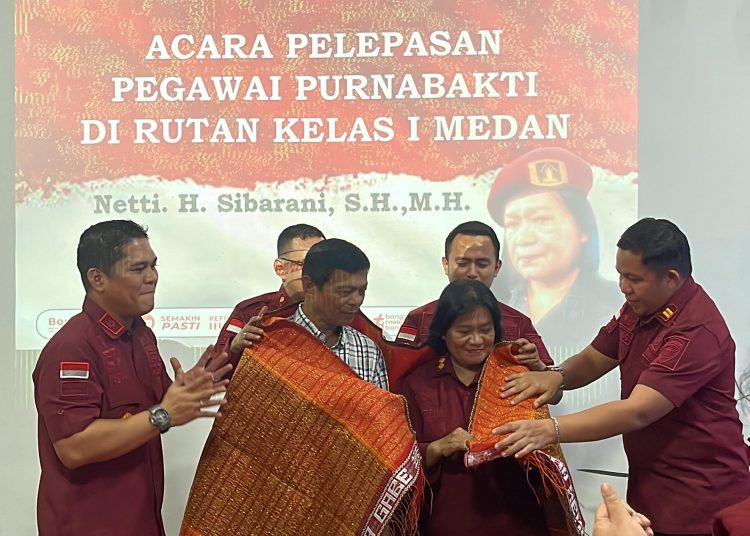 Kepala Rutan Kelas I Medan, Alanta Imanuel Ketaren (kiri) saat mengulosi   Kasubsi Urusan Umum, Netti Herawati Sibarani yang telah memasuki masa purna bhakti terhitung mulai tanggal 1 Desember 2024.(Satunusantara news/HO-Humas Rutan Medan).