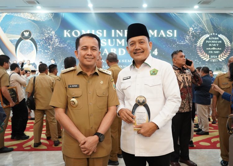 Kepala Bagian Tata Usaha Kanwil Kemenag Sumut Drs. H. Muhammad Yunus, MA (kanan) saat menerima penghargaan Anugerah Keterbukaan Informasi Publik Tahun 2024 dari Penjabat (Pj) Gubernur Sumatera Utara Agus Fatoni (kiri) di  di Aula Raja Inal Siregar.(Satunusantara news/HO-Humas Kemenag Sumut).