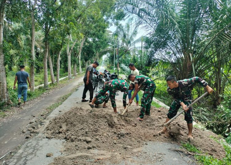 Prajurit Yonif 126/KC gotong royong melaksanakan  Penimbunan Jalan yang berlobang akibat amblas yang berada pada akses jalan di Desa Benteng Jaya, Kecamatan Sei Balai, Kabupaten Batu Bara.(Satunusantara news/HO-Yonif 126/KC).