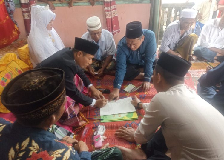 Kepala KUA Kecamatan Pulau-Pulau Batu, Ian Maisa Sembiring (dua dari kiri) saat melaksanakan acara akad Nikah bagi warga masyarakat di Pulau Telo, Kabupaten Nisel.(Satunusantara news/HO- Humas Kemenag Sumut).