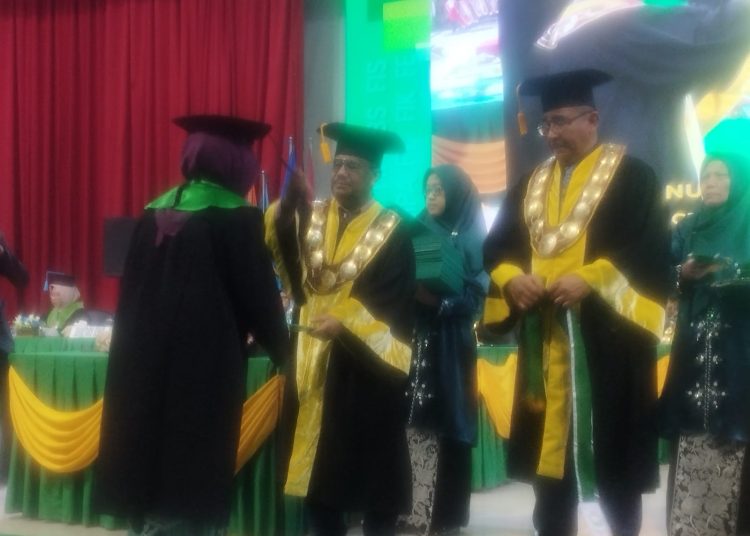 Rektor Unimed Prof. Dr. Baharuddin, ST, M.Pd  (tengah) saat mewisuda salah seorang wisudawan di Gedung Auditorium Unimed.(Satunusantara news/Munawar).