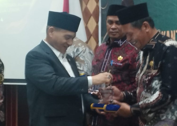 Wakil Menteri Agama RI, KH. Romo R. Muhammad Syafi’i (Kiri) saat menyerahkan langsung Humas dan PPID Award Kanwil Kementerian Agama Provinsi Sumut pada Raker Kanwil Kemenag Sumut.(Satunusantara news/Munawar).