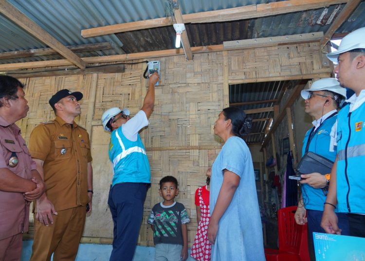 General Manajer PLN UID Sumut, Agus Kuswardoyo (tengah)  saat penyalaan listrik rumah miik Ibu Dewi Sartika di Desa  Tualuh yang disaksikan Camat Namorambe , Febri Gurusinga.(Satunusantara news/HO-Humas PLN UID Sumut).