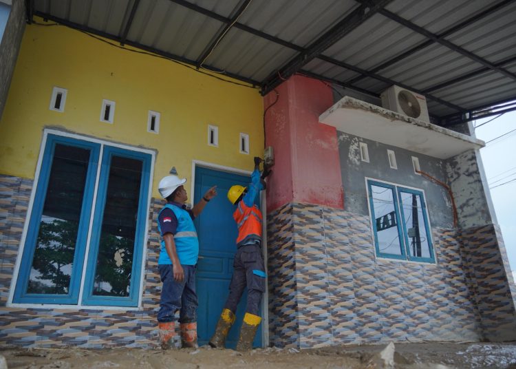 Petugas PLN saat melakukan perbaikan meteran listrik rumah warga pascaterendam banjir di wilayah Parapat,Kabupaten Simalungun.(Satunusantara news/HO-Humas PLN UID Sumut).