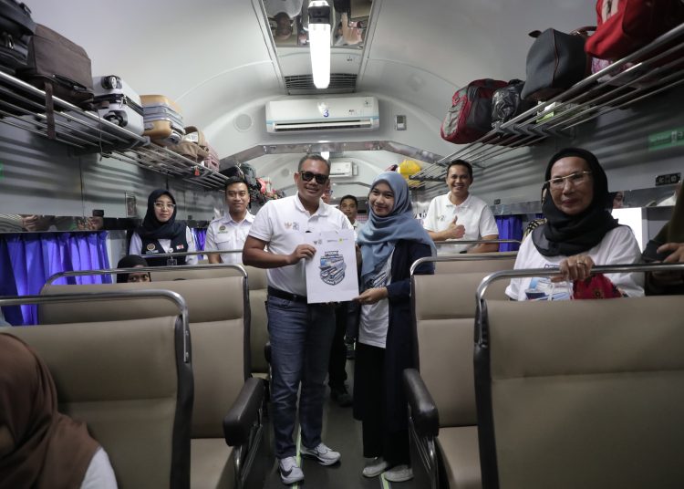 General Manajer PLN UID Sumut, Agus Kuswardoyo (tengah) saat memberikan bingkisan kepada salah seorang peserta pemudik dalam program Mudik Bersama BUMN 2025.(Satunusantara news/HO-Humas PLN UID Sumut).