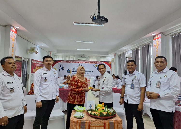 Kepala Rutan Kelas I Labuhan Deli, Eddy Junaedi (nomor tiga kanan) saat menyerahkan nasi tumpeng kepada salah seorang karyawan pada peringatan  Hari Bhakti Pemasyarakatan ke-61 di Rutan Labuhan Deli.(Satunusantara news/HO-Rutan Labuhan Deli).