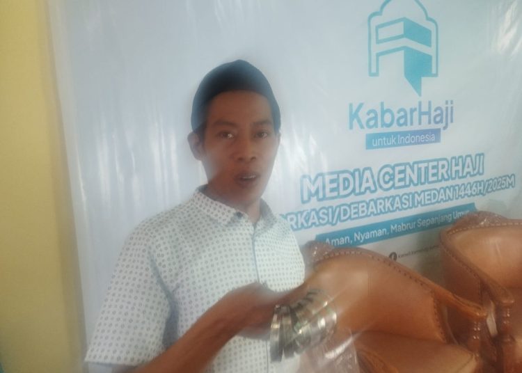 Muhammad Jumah (32) pengrajin gelang besi dari Jepara, Jawa Tengah, saat memperlihatkan gelang besi warna hijau tua yang dibuat untuk jemaah haji Embarkasi Medan.(Satunusantra news/Munawar).