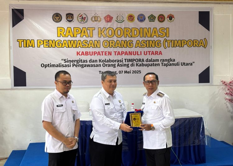 Kakanwil Ditjen Imigrasi Sumut, Teodorus Simarmata (tengah) saat memberikan cendramata kepada Bupati Taput, Jonius Taripar Parsaoran Hutabarat (kanan) usai Rapat TIMPORA di Kota Tarutung.(Satunusantara newsHO-Kanwil Ditjen Imigrasi Sumut).
