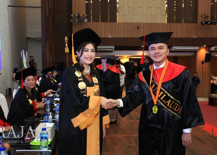 Rektor UNPRI Prof. Dr. Chrismis Novalinda Ginting, M.Kes (kiri) saat bersalaman dengan seorang wisudawan  UNPRI, di Kampus Utama UNPRI, Jalan Sampul Medan.(Satunusantara news/HO-Humas UNPRI).