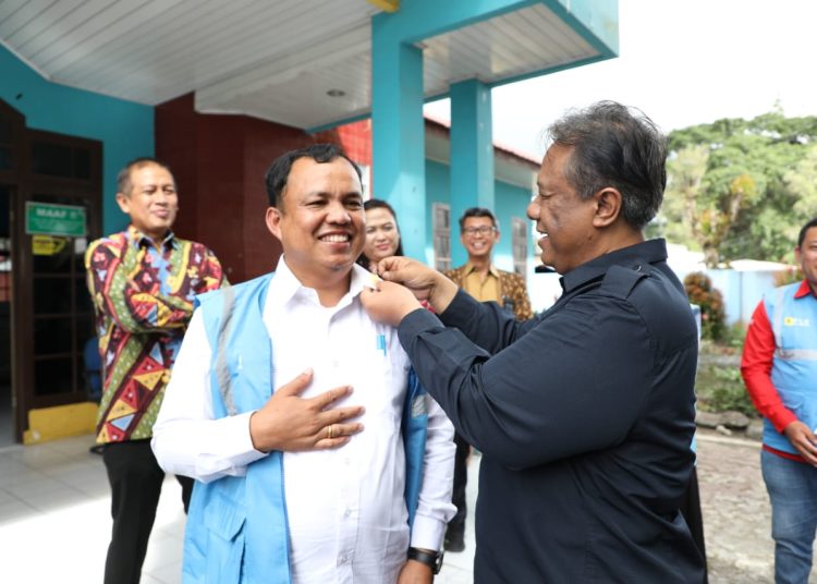 Direktur  LHC PT PLN (Persero), Yusuf Didi Setiarto (kanan) saat menyematkan Pin PLN kepada Manajaer ULP Dolok Sanggul.(Satunusantara news/HO- Humas PLN UID Sumut).