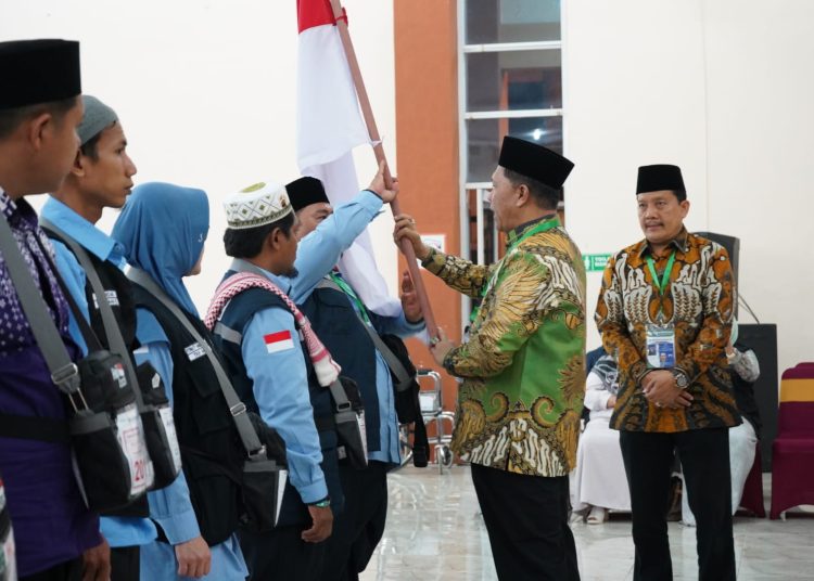 Ketua PPIH Embarkasi Medan H. Ahmad Qosbi (tengah) saat melepas keberangkatan jemaah calhaj Kloter 09, dan menyerahkan Pataka Merah Putih kepada TPHI Kloter 09, M. Lukman Hakim Hasibuan, di Asrama Haji Medan.(Satunusantara news/HO-Humas PPIH Embarkasi Medan).