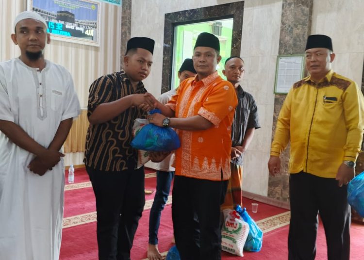 Kasi Bimas Islam Kemenag Kabupaten DelI Serdang, H. Mulia Banurea, S.Ag,M.Si (dua kanan) saat menyeraahkan bantuan Jumat Barakah kepada  keluarga yang kurang mampu di Masjid Al Hikmah.(Satunusantara news/HO-Humas Kanwil Kemenag Sumut).