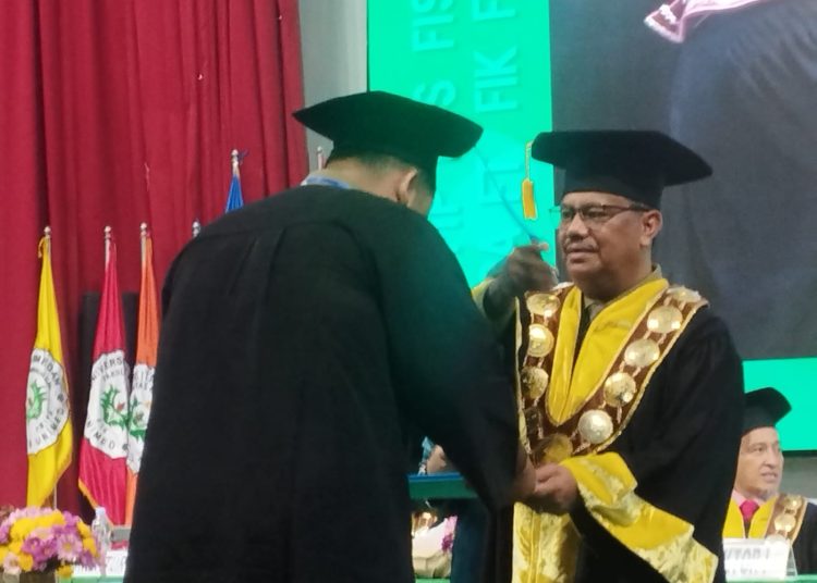 Rektor Unimed Prof. Dr. Baharuddin, ST, M.Pd, (kanan) saat mewisuda seorang wisudawan  di Gedung Auditorium Unimed.(Satunusantara news/Munawar).