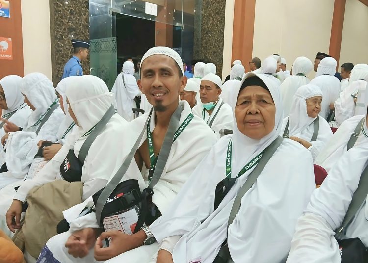 Nenek Marni binti Poksum (68) penjual serabi di Kota Tebing Tinggi (kanan) bersama putranya Agus Suhendra, tergabung di Kloter 16, saat berada di Asrama Haji Medan.(Satunusantara news/Humas PPIH Embarkasi Medan).