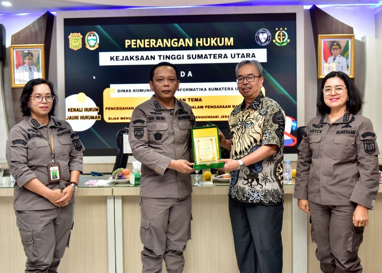 Sekretaris Dinas Kominfo Sumut Achmad Yazid Matondang (Dua kanan) saat menyerahkan cendramata kepada  Kasi Penerangan Hukum Kejati Sumut Andre Wanda Ginting.(Satunusantara news/HO-Diskominfo Sumut).