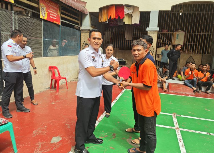 Kepala Rutan Kelas I Labuhan Deli , Eddy Junaidi (kiri) saaat salaman dengan warga binaan yang sedang mengikuti kegiatan olahraga teni meja di dalam lapangan Blok Hunian Rutan Labuhan.(Satunusantara news/HO-Rutan Labuhan Deli).