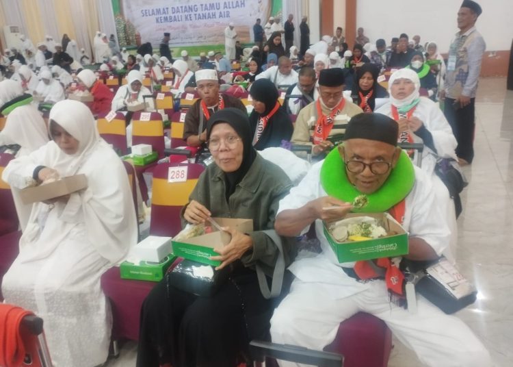 Jemaah haji Kloter 01 Debarkasi Medan asal Kota Padangsidimpuan, yang baru tiba dari Kota Jeddah, menyantap nasi kotak di Asrama Haji Medan.(Satunusantara news/Munawar).