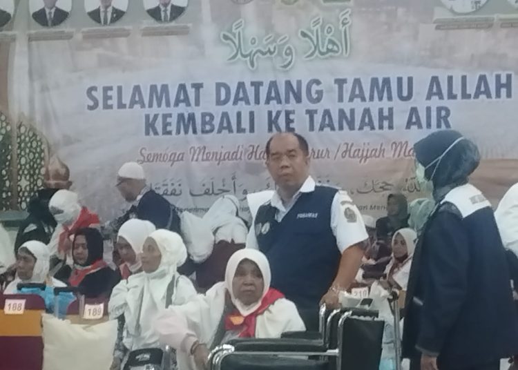Salah seorang jemaah haji lansia yang tergabung di Kloter 14 Debarkasi Medan, dibantu petugas haji saat meninggalkan Asrama Haji Medan.(Satunusantara news/Munawar).
