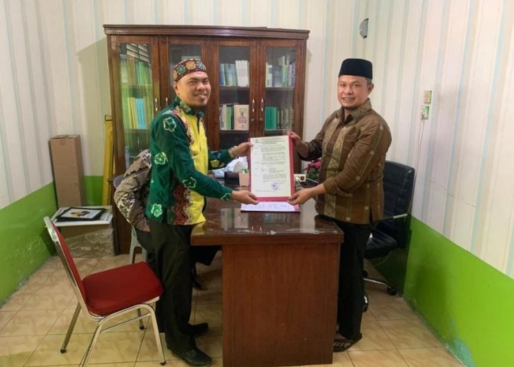 Kasi Bimas Islam, Kemenag Deli Serdang, H.Mulia Banurea (kanan) saat menyerahkan SK kepada Amru Hasibuan, S.Hi, sebagai Plt KUA Kecamatan Pantai Labu.(Satunusantara News/HO-Humas Kemenag Deli Serdang).