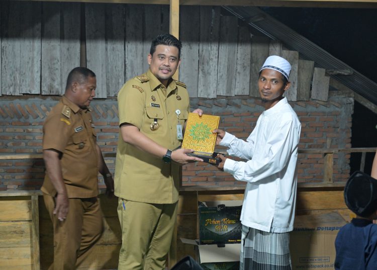 Gubernur Sumatera Utara Bobby Nasution (kiri) saat menyerahkan bantuan kepada warga mengunjungi Desa Pulau Kampai, Kecamatan Pangkalan Susu Kabupaten Langkat.(Satunusantara news/HO-Diskominfo Sumut)