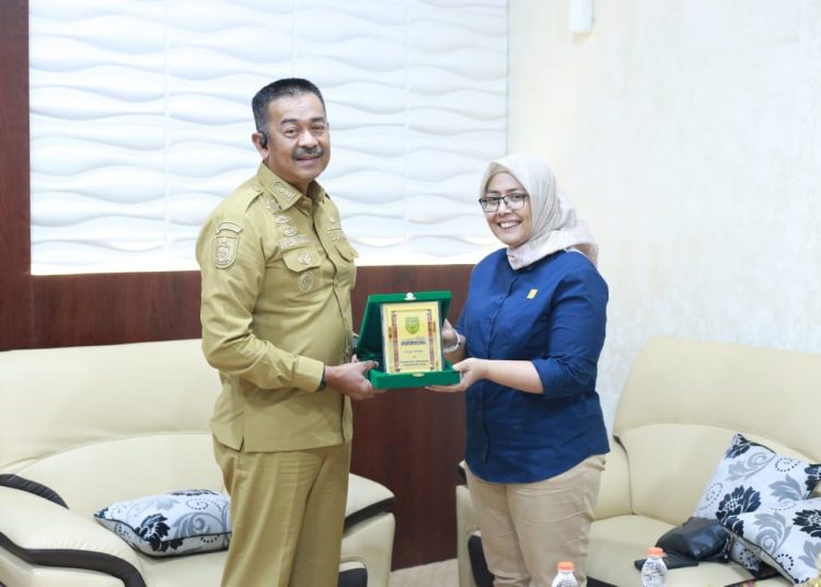 Manajer PLN UP3 Padangsidimpuan, Yessi Indra (kanan) saat menerima cendramata dari  Bupati Mandailing Natal, Saipullah Nasution (kanan) di Panyabungan.(Satunusantara news/HO-Humas PLN UID Sumut).