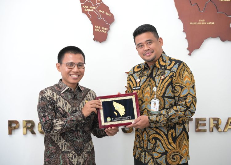 Gubernur Sumatera Utara Muhammad Bobby Afif Nasution (kanan) saat menyerahkan cendramata kepada General Manajer PLN Unit Induk Distribusi Sumut Ahmad Syauki.(Satunusantara news/HO-Diskominfo Sumut).