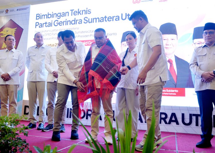 Gubernur Sumut  Muhammad Bobby Afif Nasution (kanan) saat mengulosi  Wakil Ketua DPR RI yang juga Ketua Harian Partai Gerindra Sufmi Dasco Ahmad, menghadiri Bimtek Partai Gerindra Sumut,  di Medan.(Satunusantara news/HO-Diskominfo Sumut).