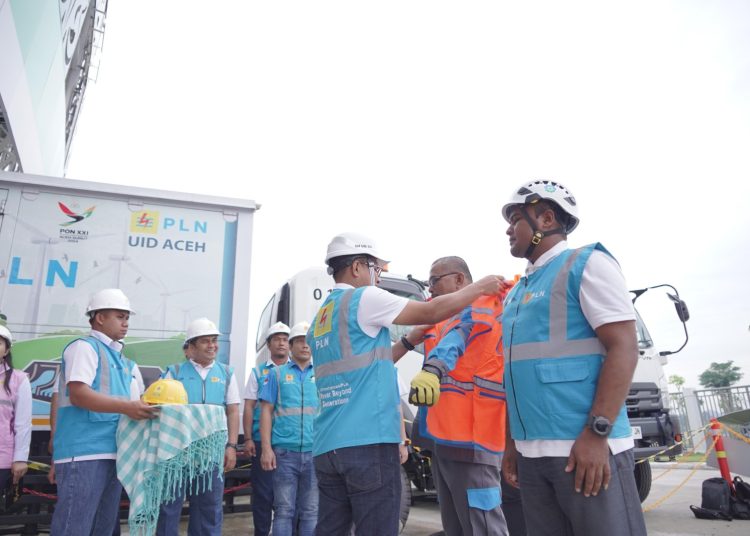 General Manajer PLN UID Sumut  Ahmad Syauki (tengah) saat memasangkan rompi dan helm kepada petugas Pelayanan Teknik dan Pegawai Siaga.(Satunusantara news/HO-Humas PLN UID Sumut)