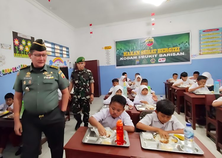Pamen Ahli Bidang Ideologi Politik Kodam I/BB Kolonel Arm Eric C. Simanjuntak (kiri) saat meninjau  pemberian Makan Sehat Bergizi kepada siswa SDN Nomor 101767 di Desa Tembung, Kecamatan Percut Sei Tuan, Kabupaten Deli Serdang.(Satunusantara news/HO-Pendam I/BB)