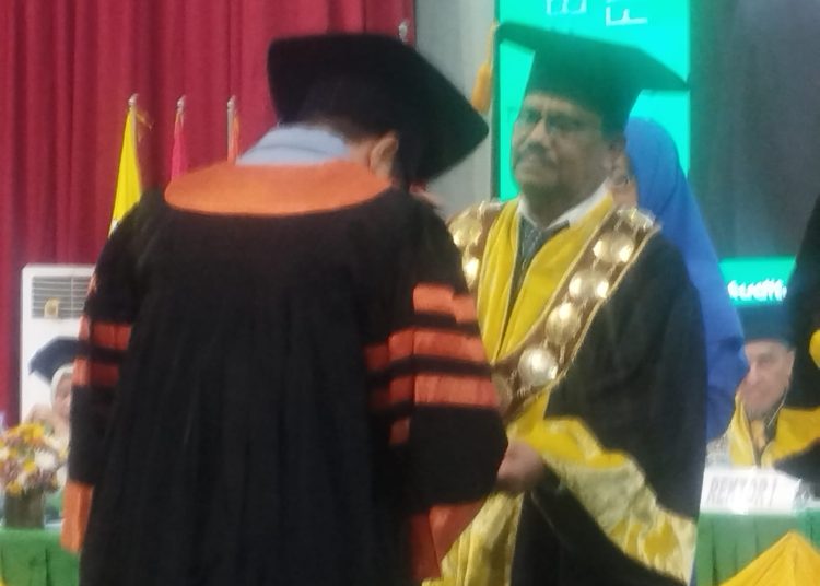 Rektor Unimed Prof Dr Baharuddin, ST, MPd, (kanan) saat mewisuda  salah seorang wisudawan di Unimed.(Satunusantara.news/Munawar).